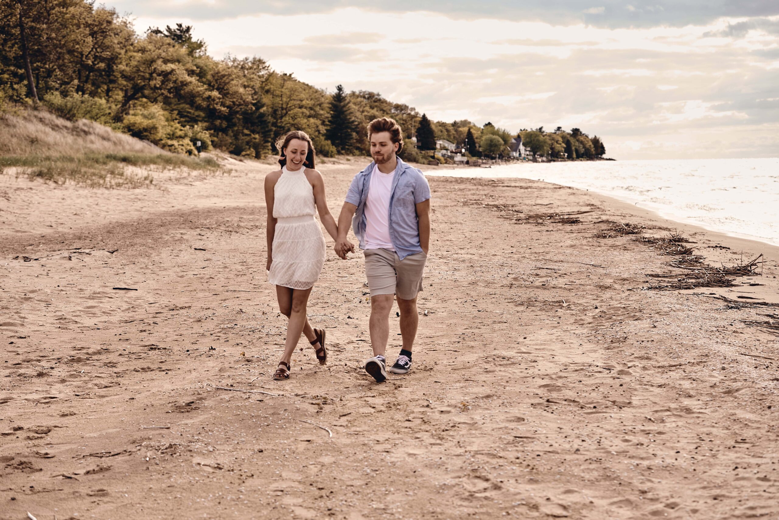 Couple walking on beach holding hands at Sleeper State Park in Caseville, Michigan