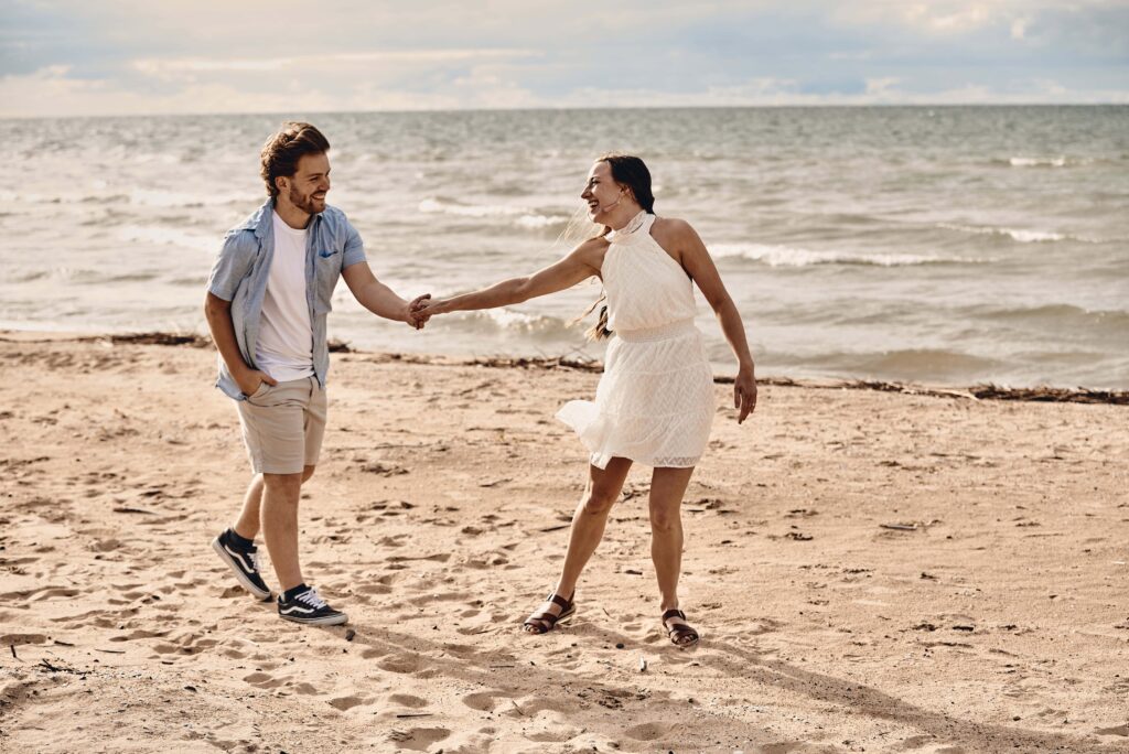 Couple walking together on a beach at Sleeper State Park along Lake Huron in the Thumb of Michigan. Photo taken by Erika Black Photography