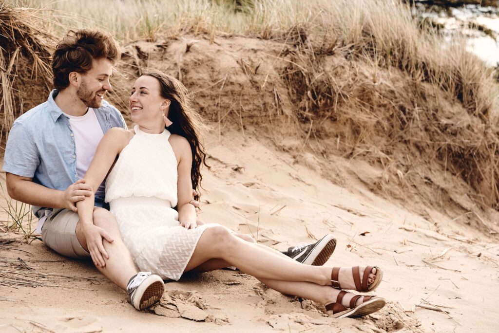 Couple sits on sandy beach at Sleeper State Park in Caseville, Michigan