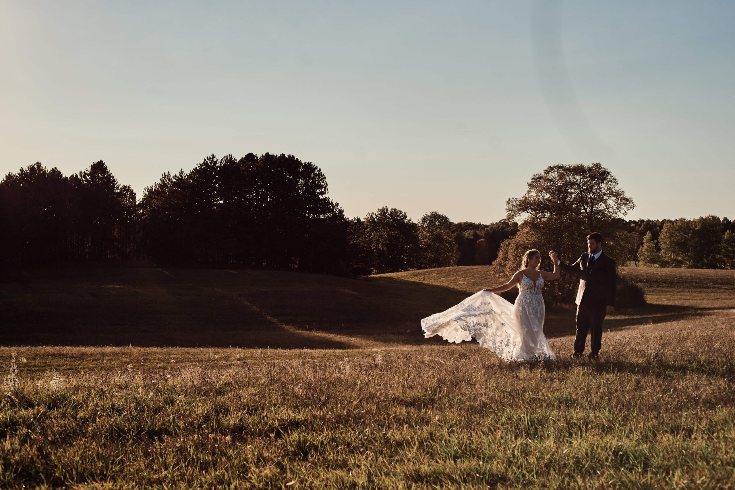 Wedding Couple on rolling hills at Sunset Hill Wedding Barn in Center Lake, Michigan