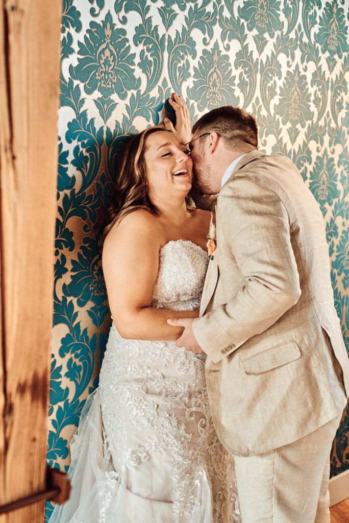 Groom whispers sweet nothings into the bride's ear making her laugh at The Cheney Place in Grand Rapids, MI. Photo taken by Erika Black Photography