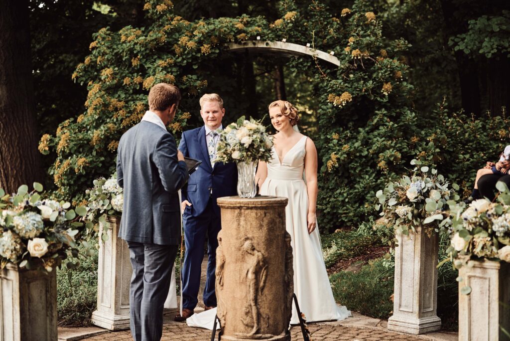 Couple standing together during their ceremony at the Kellogg Manor House in Kalamazoo, MI. Photo taken by Erika Black Photography