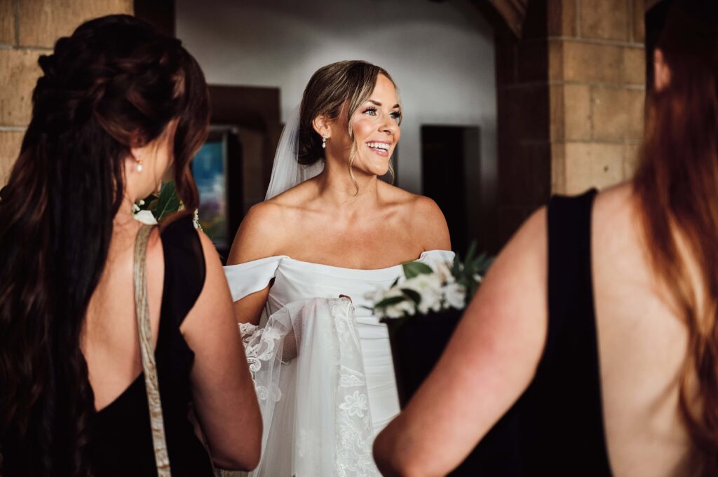 The bride shares a moment with the bridesmaids as they get ready to leave for the ceremony at the Country Club of Detroit
