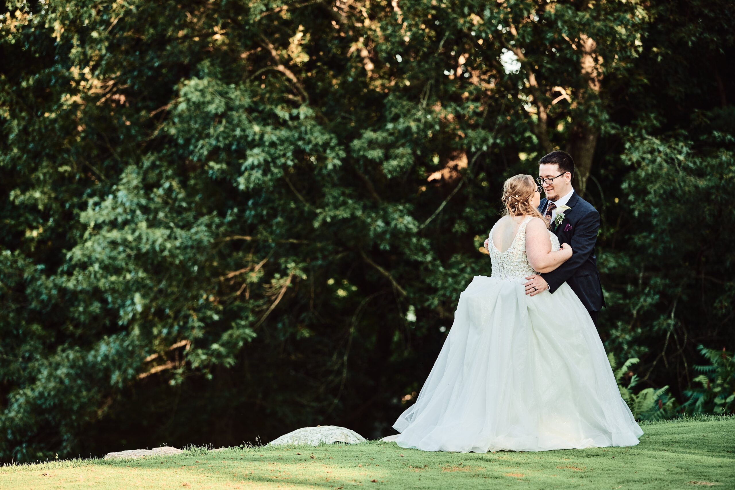 Bride and groom pose at sunset on the putting green