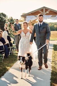 Bride and Groom exit their ceremony with their dog at Sunset Hill Wedding Barn in Central, Michigan
