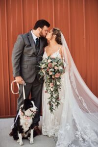 Bride and Groom with their dog outside of Sunset Hill Wedding Barn