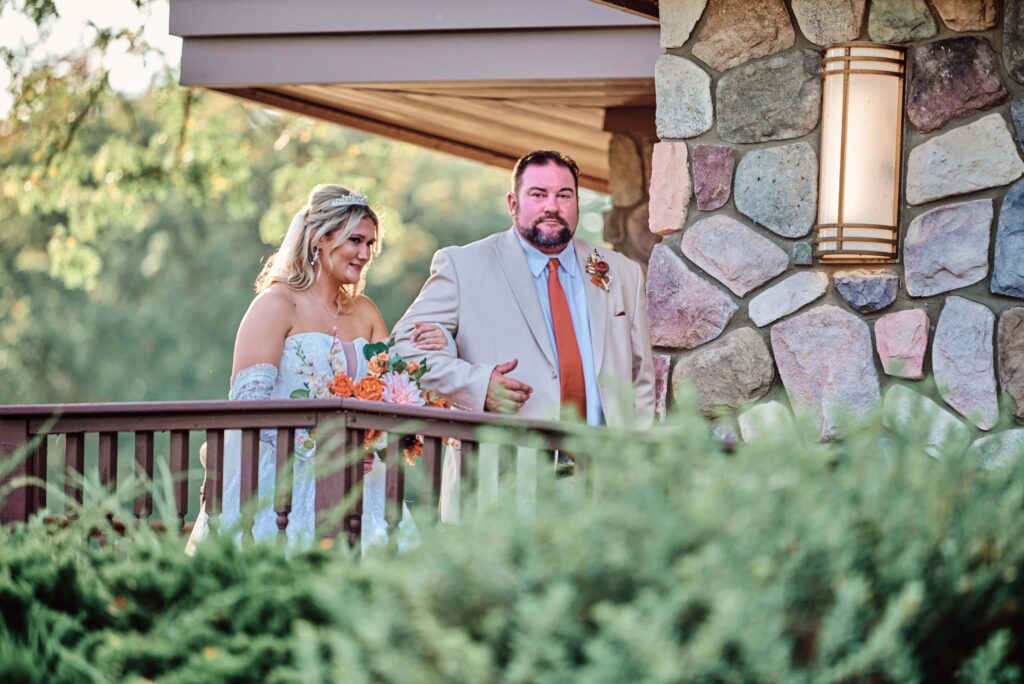 Bride and father of the bride start their decent down the aisle for the wedding ceremony at Lapeer Country Club