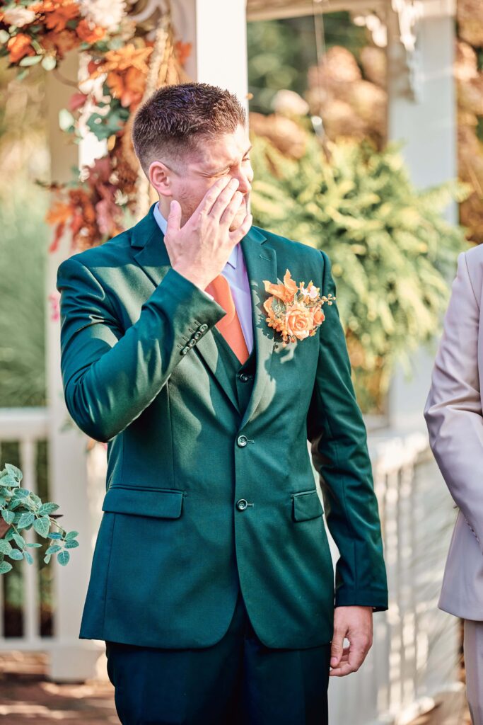 Emotions overwhelm the groom as the bride walks down the wedding ceremony aisle at Lapeer Country Club