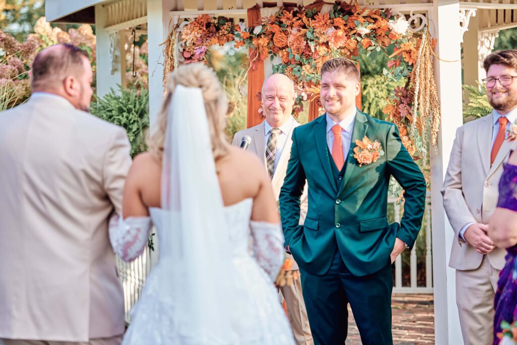 The bride and her father approach the groom on their wedding day at Lapeer Country Club