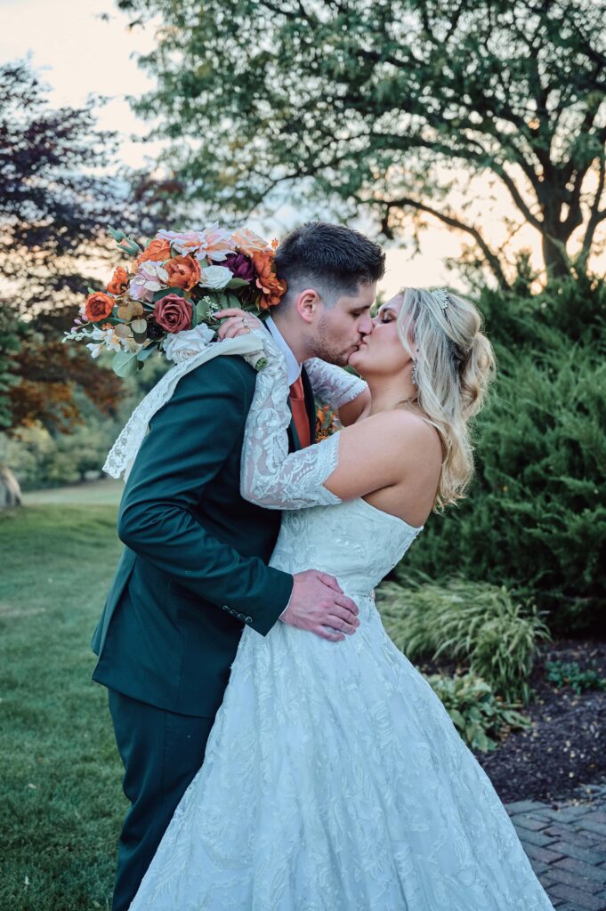 The bride and groom kiss each other at Lapeer Country Club