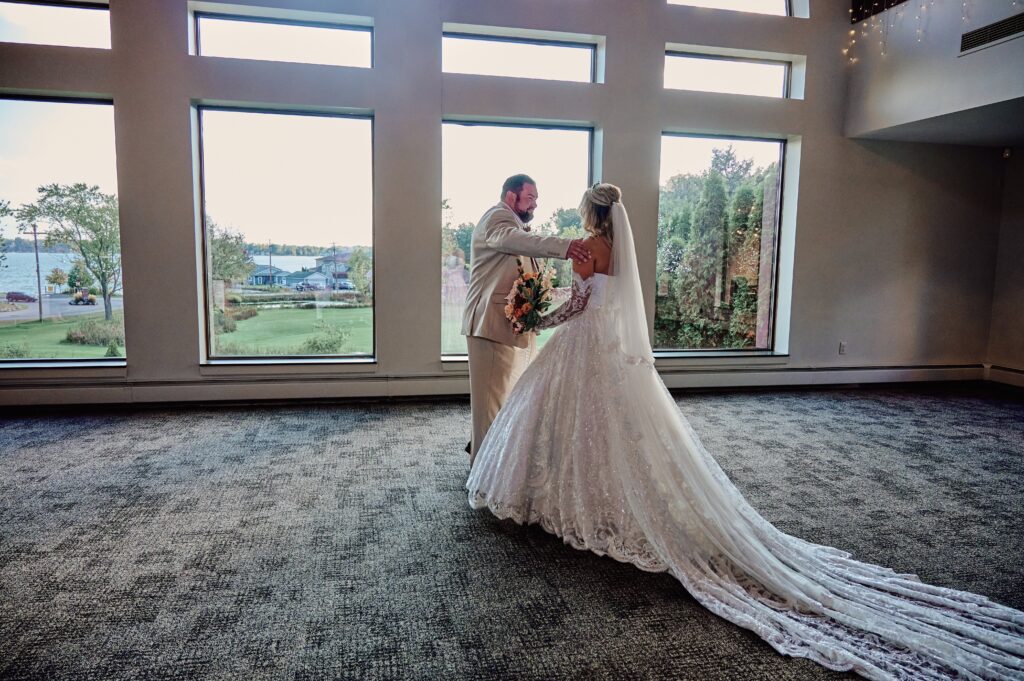 Father goes in for an emotional hug of his daughter, the bride, on her wedding day at Lapeer Country Club
