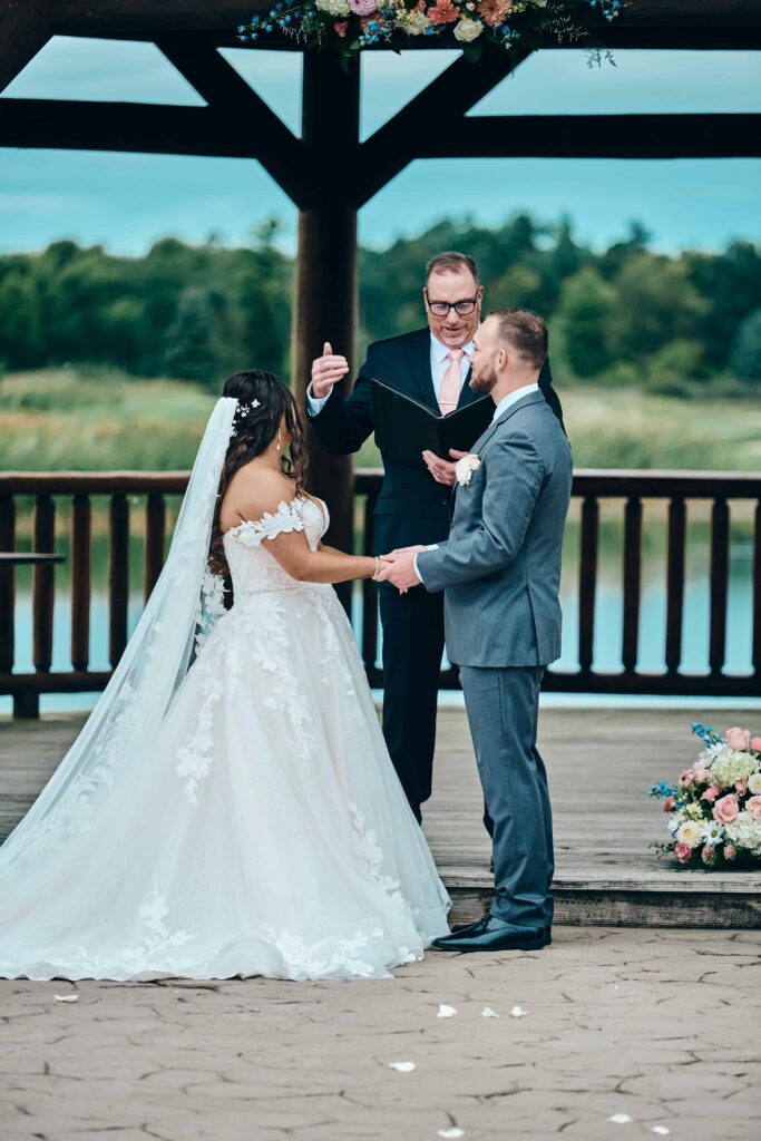 The officiant talks while the bride and groom hold hands during their wedding ceremony at Solitude Links Golf Course