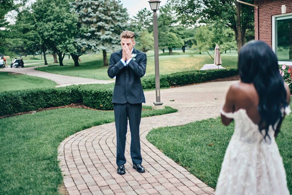 The groom turns around and reacts emotionally to seeing the bride for the first time before their wedding ceremony