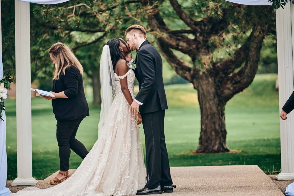 The bride and groom take their first kiss at the end of the wedding ceremony