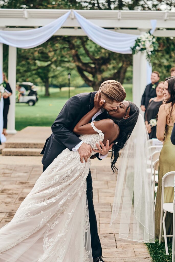 The bride and groom take a second dipping kiss after they walk back up the aisle